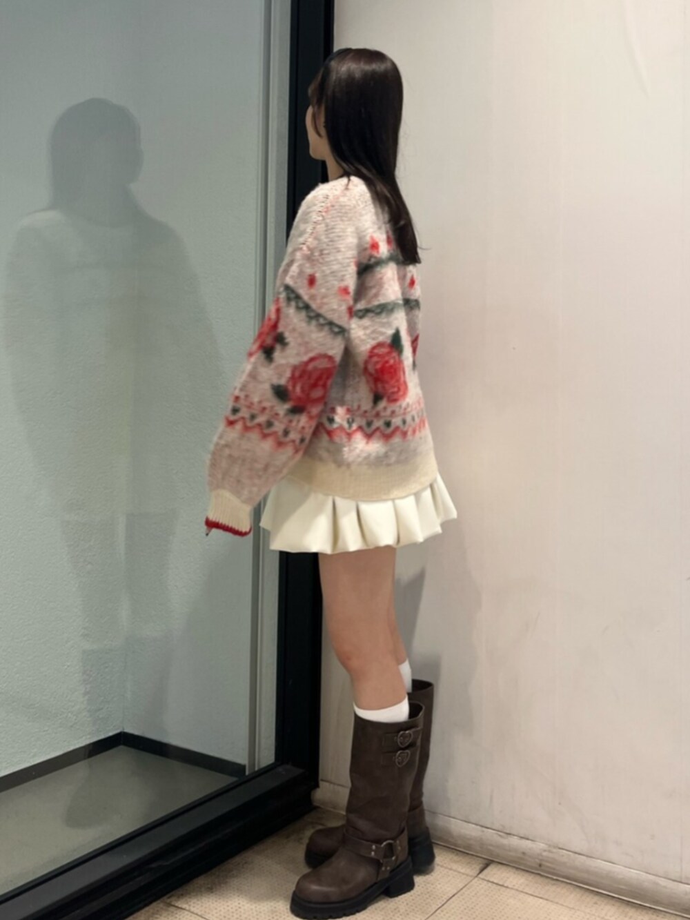 ブラウン系のブーツ、ホワイト系のニット/セーター、ホワイト系のスカートを着用したレディースの秋コーディネートの2枚目の写真