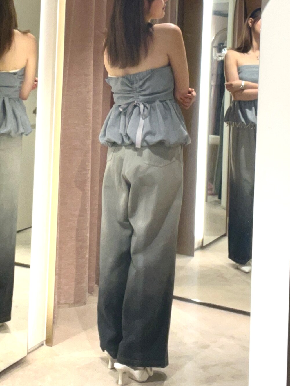 ホワイト系のサンダル、グレー系のデニムパンツ、グレー系のチューブトップを着用したレディースの夏コーディネートの4枚目の写真