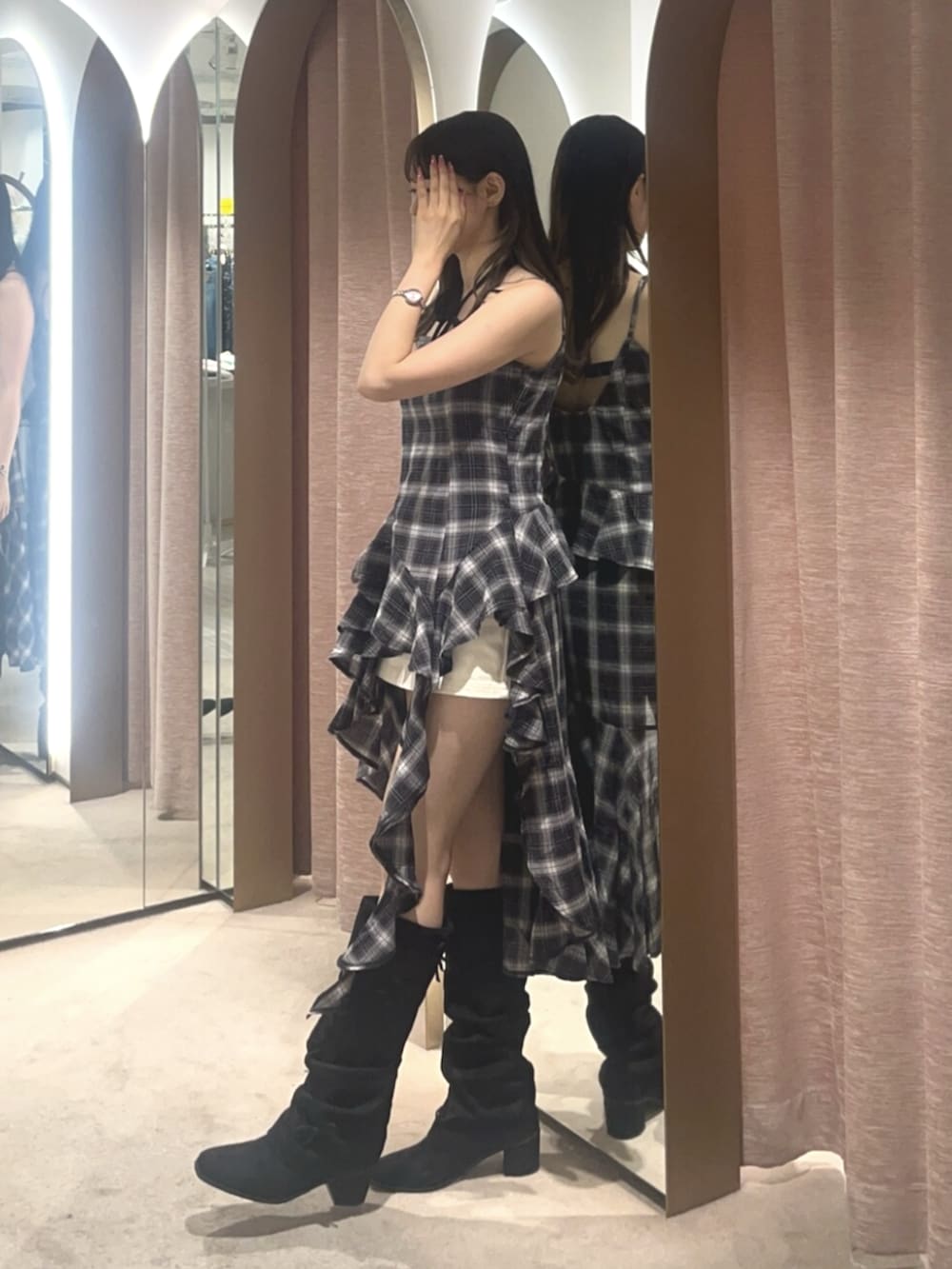ブラック系のワンピース、ホワイト系のスカート、ブラック系のブーツを着用したレディースの夏コーディネートの2枚目の写真
