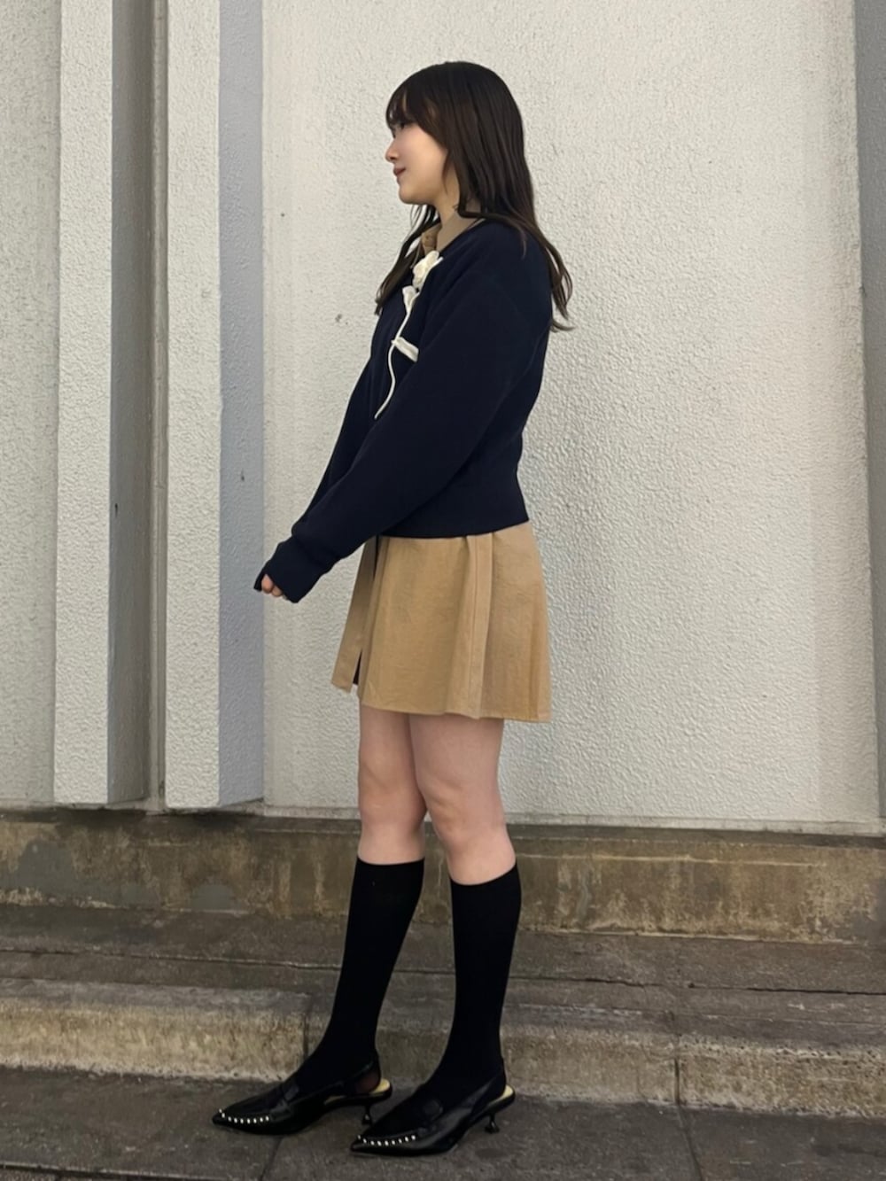 ブルー系のニット/セーター、ベージュ系のシャツワンピース、ブラック系のサンダルを着用したレディースの春コーディネートの2枚目の写真