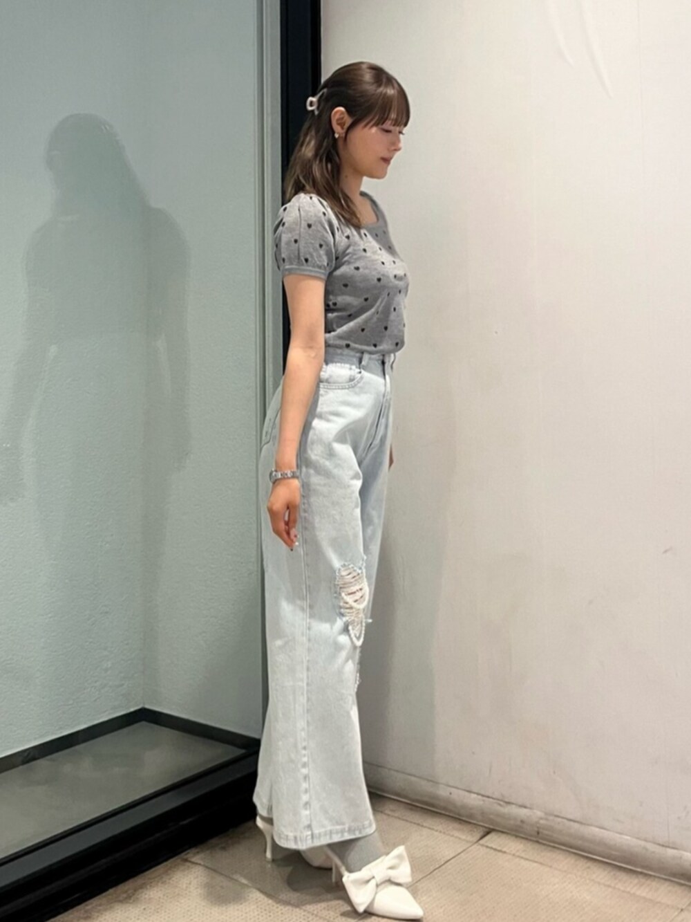 ブルー系のデニムパンツ、ホワイト系のサンダル、グレー系のTシャツ/カットソーを着用したレディースの夏コーディネートの2枚目の写真