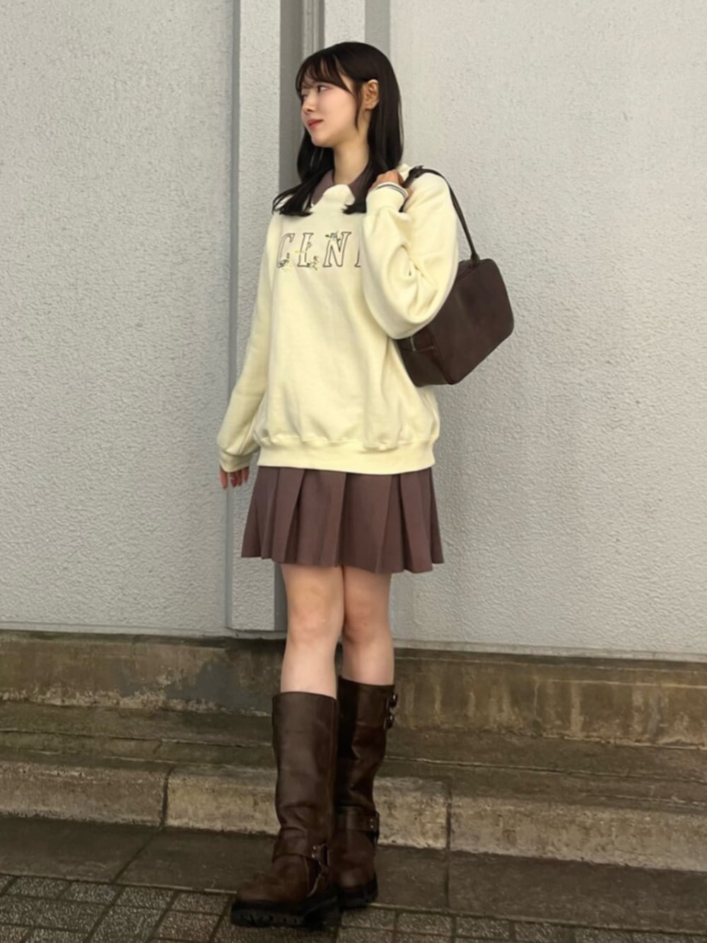 ブラウン系のブーツ、イエロー系のスウェット、ブラウン系のワンピースを着用したレディースの秋コーディネートの2枚目の写真