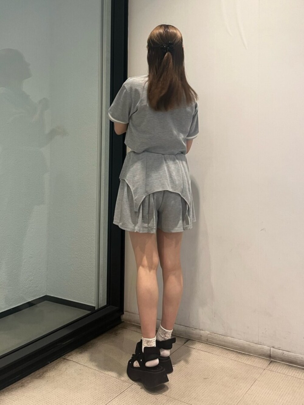 グレー系のワンピース、ブラック系のサンダルを着用したレディースの夏コーディネートの3枚目の写真