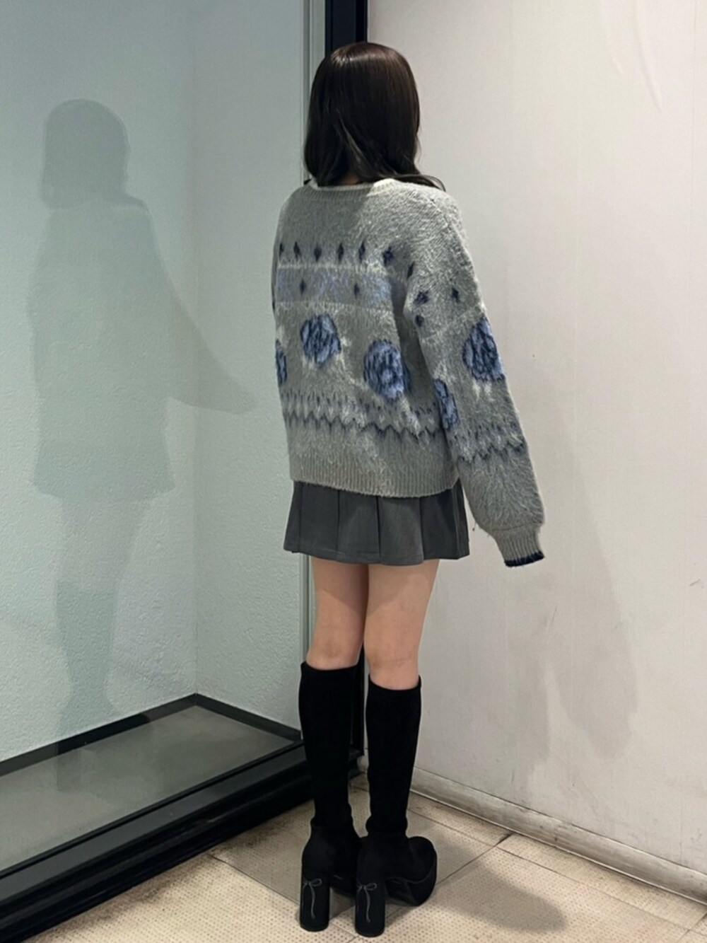 ブラック系のブーツ、グレー系のニット/セーター、グレー系のスカートを着用したレディースの秋コーディネートの3枚目の写真