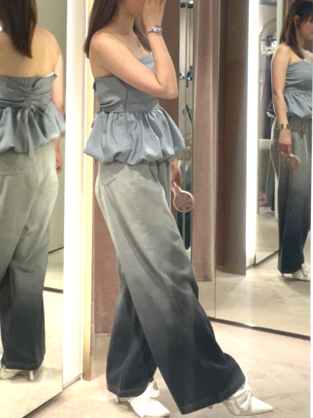 ホワイト系のサンダル、グレー系のデニムパンツ、グレー系のチューブトップを着用したレディースの夏コーディネートの3枚目の写真