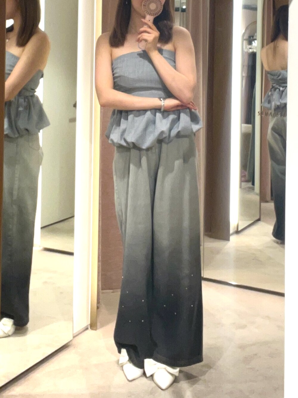 ホワイト系のサンダル、グレー系のデニムパンツ、グレー系のチューブトップを着用したレディースの夏コーディネートの2枚目の写真