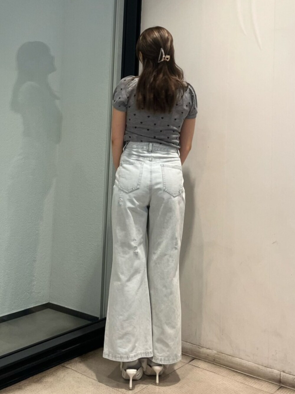 ブルー系のデニムパンツ、ホワイト系のサンダル、グレー系のTシャツ/カットソーを着用したレディースの夏コーディネートの3枚目の写真