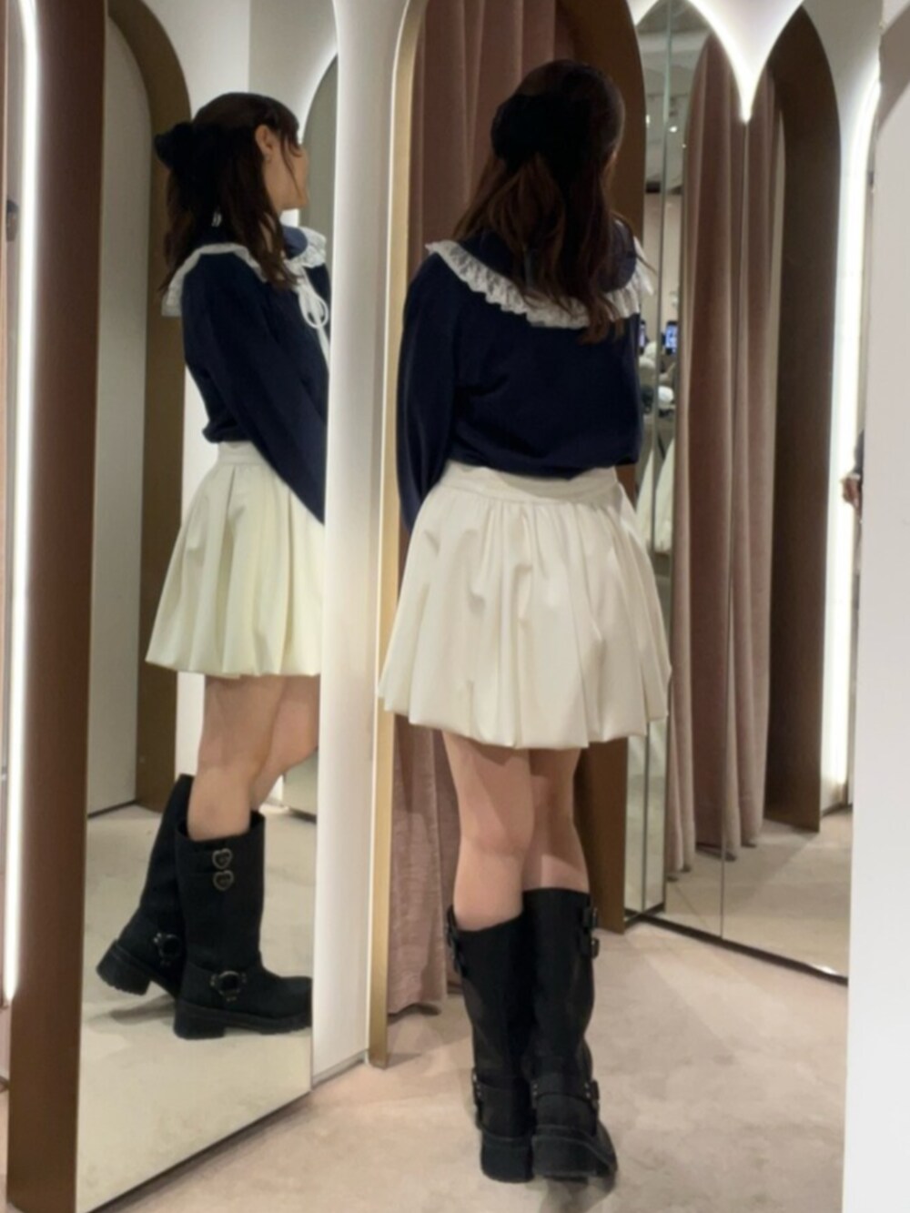 ブラック系のブーツ、ブルー系のTシャツ/カットソー、ホワイト系のスカートを着用したレディースの秋コーディネートの3枚目の写真