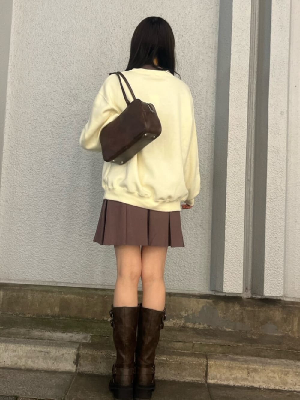 ブラウン系のブーツ、イエロー系のスウェット、ブラウン系のワンピースを着用したレディースの秋コーディネートの3枚目の写真