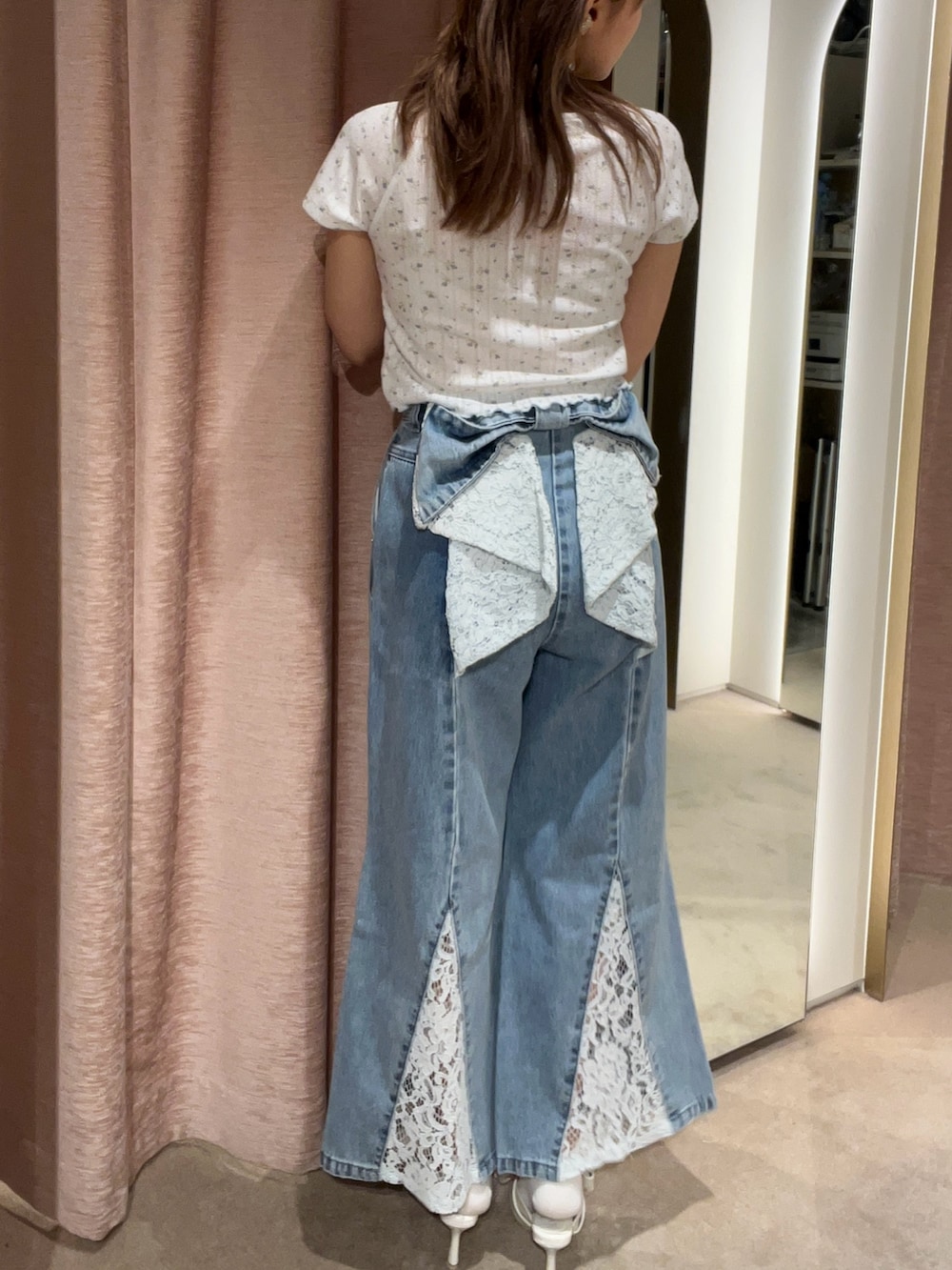 ブルー系のデニムパンツ、ホワイト系のサンダル、ブルー系のTシャツ/カットソーを着用したレディースの夏コーディネートの3枚目の写真