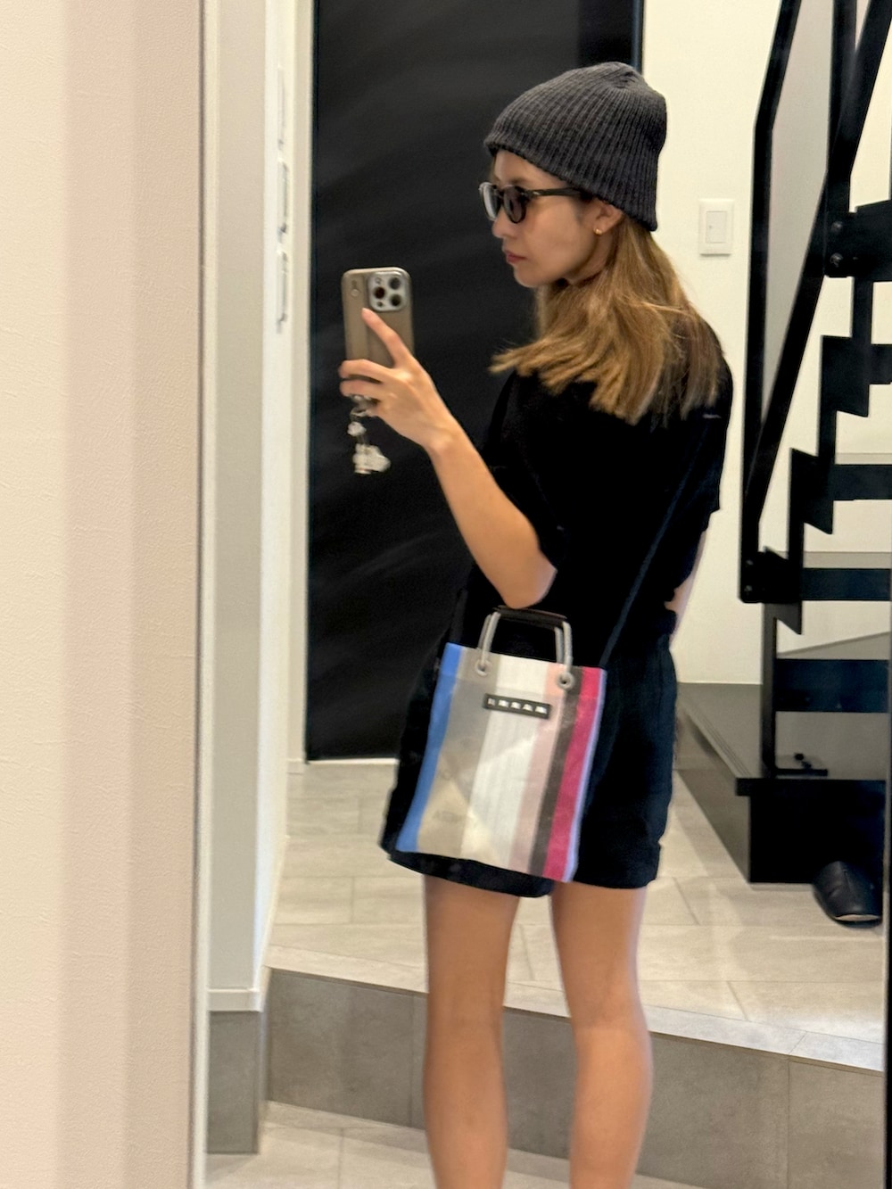 ブラック系のその他パンツ、ブラック系のポロシャツ、ブラック系のスニーカーを着用したレディースの春コーディネートの3枚目の写真