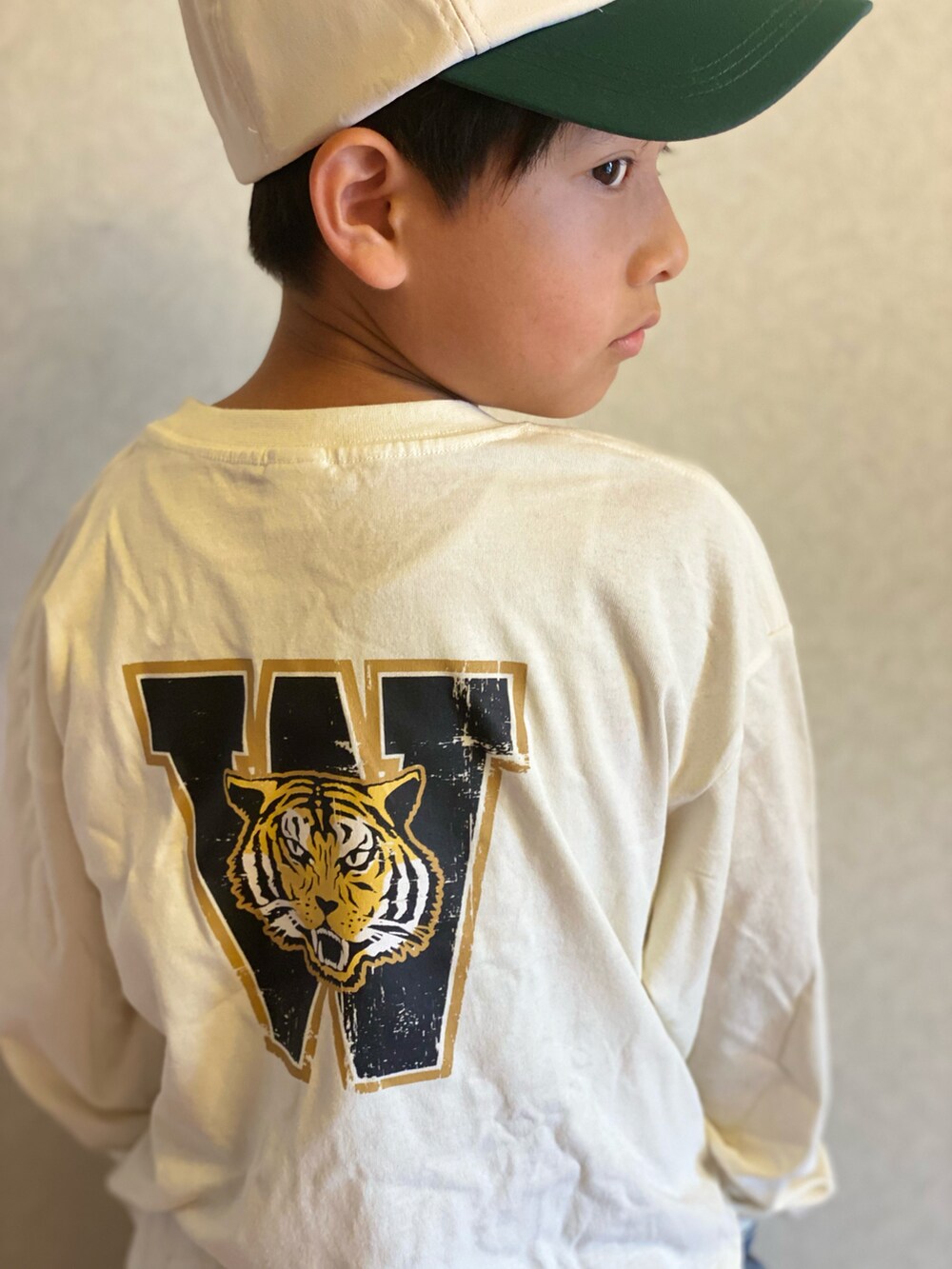 ホワイト系のTシャツ/カットソー、ブルー系のデニムパンツ、ホワイト系のキャップを着用したキッズの秋コーディネートの3枚目の写真