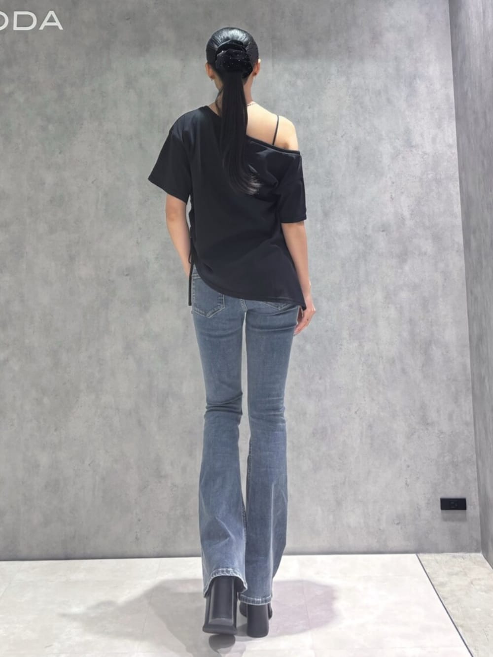 ブルー系のデニムパンツ、ブラック系のサンダル、ブラック系のTシャツ/カットソーを着用したレディースの春コーディネートの5枚目の写真