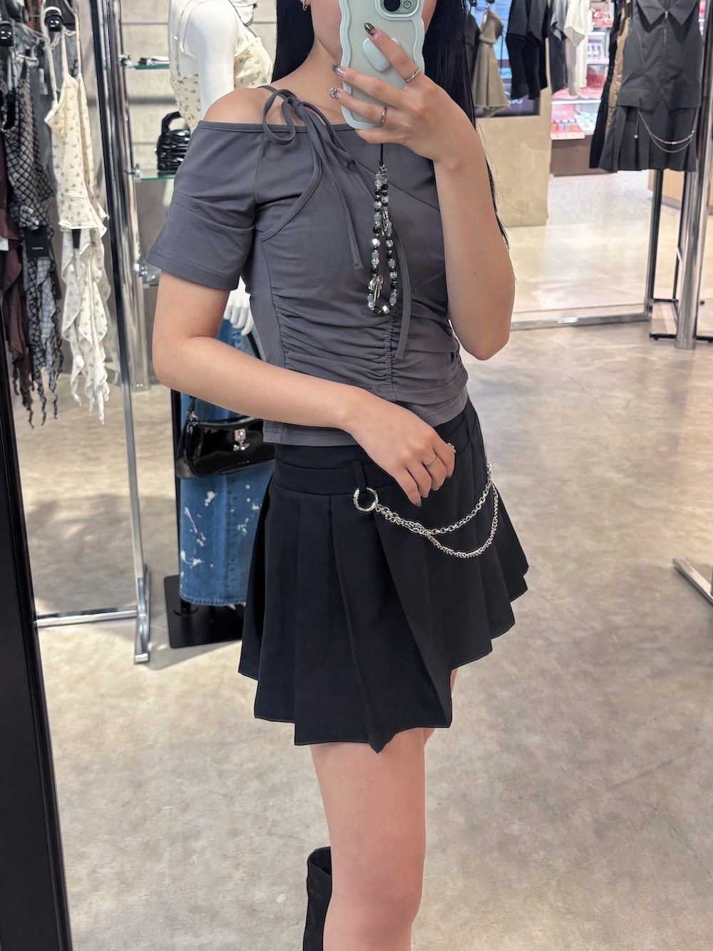 グレー系のTシャツ/カットソー、ブラック系のスカート、ブラック系のサンダルを着用したレディースの夏コーディネートの8枚目の写真