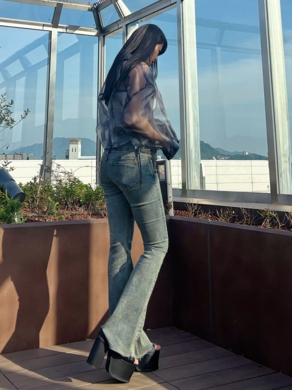 ブラック系のサンダル、ブルー系のシャツ/ブラウス、ホワイト系のTシャツ/カットソーを着用したレディースの春コーディネートの4枚目の写真