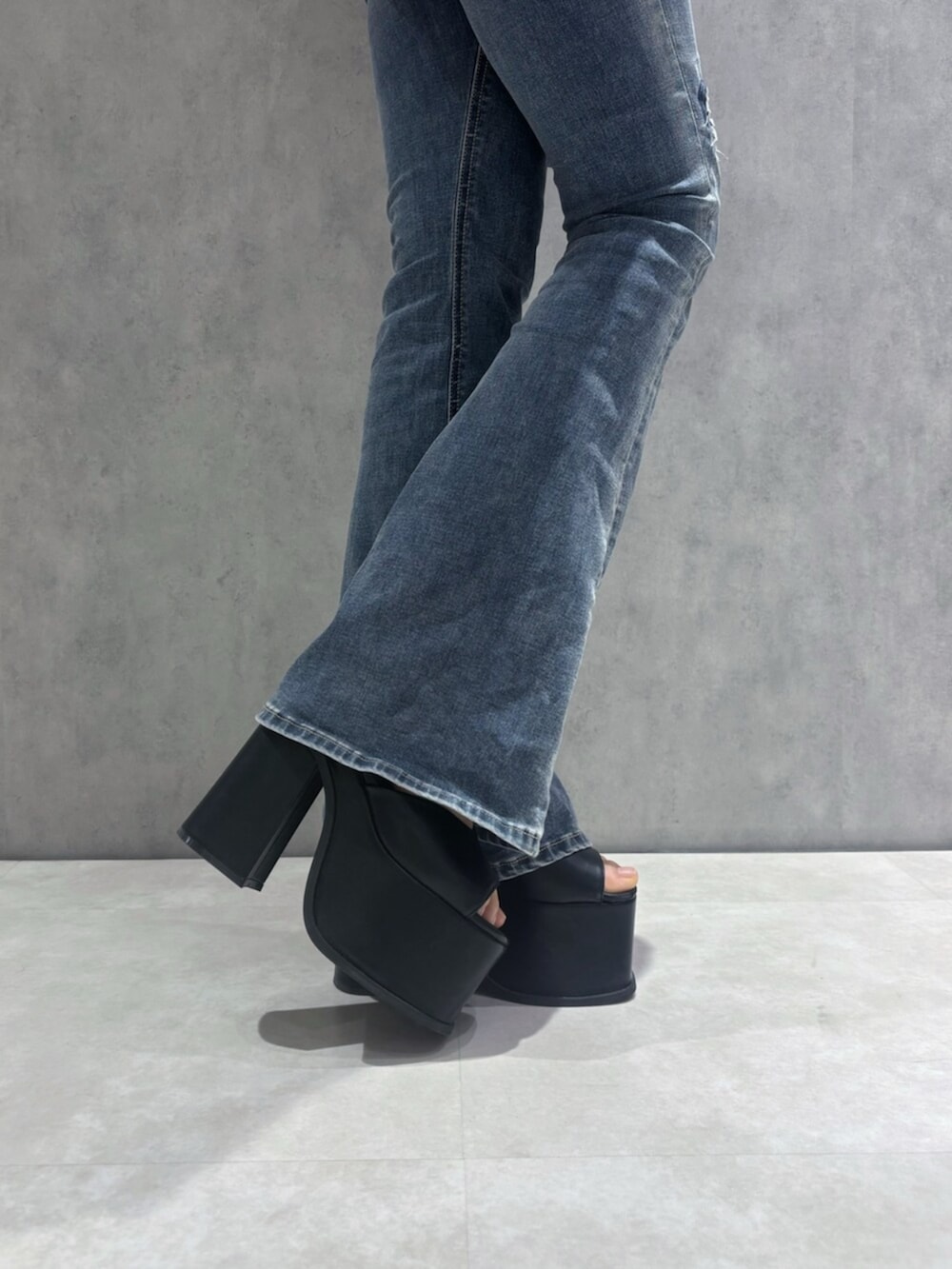 ブルー系のデニムパンツ、ブラック系のサンダル、ブラック系のTシャツ/カットソーを着用したレディースの春コーディネートの8枚目の写真