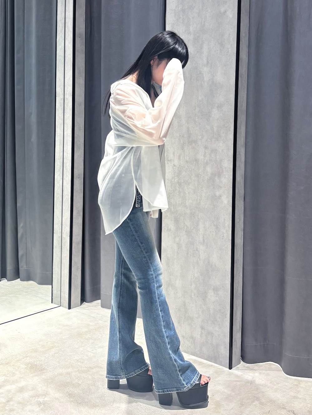 ブルー系のサロペット/オーバーオール、ホワイト系のシャツ/ブラウス、ブラック系のサンダルを着用したレディースの春コーディネートの4枚目の写真