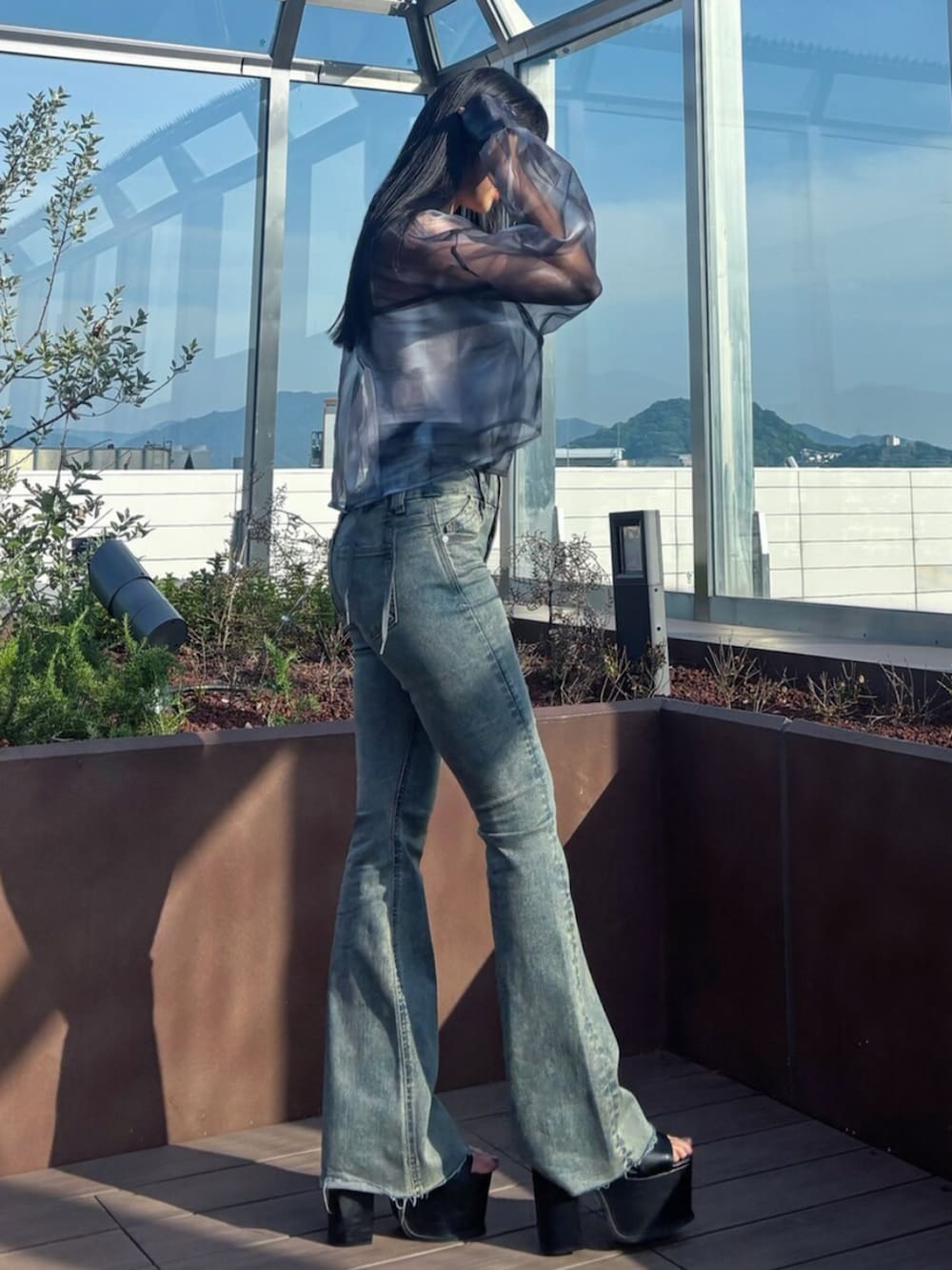 ブラック系のサンダル、ブルー系のシャツ/ブラウス、ホワイト系のTシャツ/カットソーを着用したレディースの春コーディネートの3枚目の写真