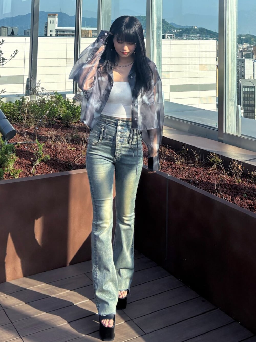 ブラック系のサンダル、ブルー系のシャツ/ブラウス、ホワイト系のTシャツ/カットソーを着用したレディースの春コーディネートの2枚目の写真