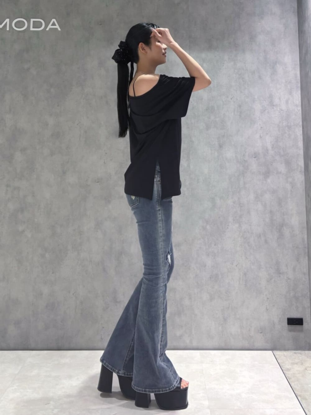 ブルー系のデニムパンツ、ブラック系のサンダル、ブラック系のTシャツ/カットソーを着用したレディースの春コーディネートの4枚目の写真