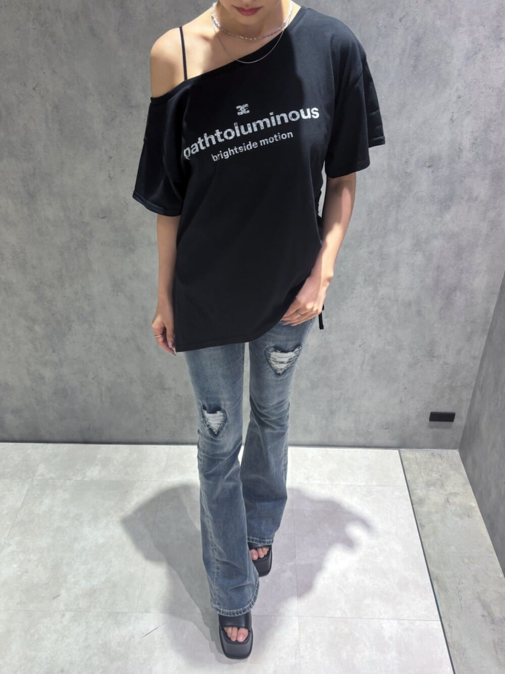 ブルー系のデニムパンツ、ブラック系のサンダル、ブラック系のTシャツ/カットソーを着用したレディースの春コーディネートの7枚目の写真