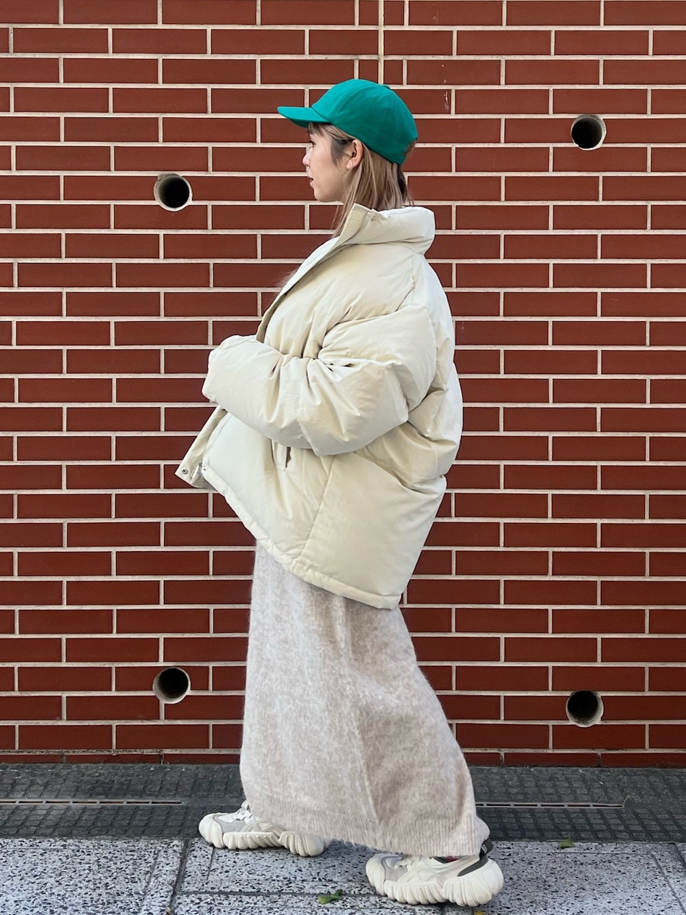 ホワイト系のワンピース、ホワイト系のダウンジャケット/コート、グリーン系のキャップを着用したレディースの秋コーディネートの3枚目の写真