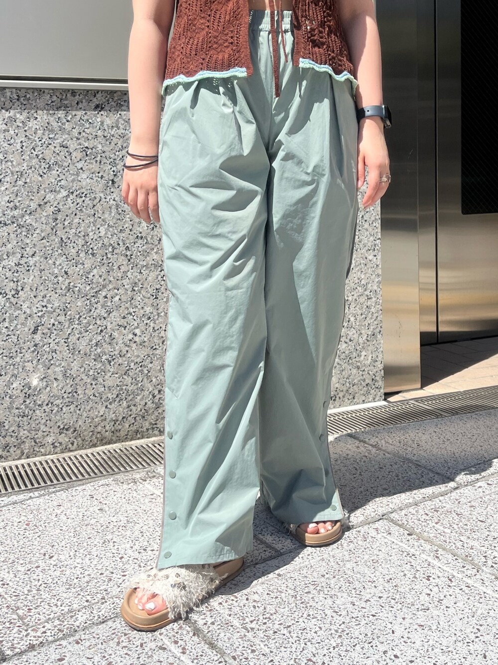 グリーン系のその他パンツ、ブラウン系のニット/セーター、ホワイト系のキャミソールを着用したレディースの春コーディネートの5枚目の写真