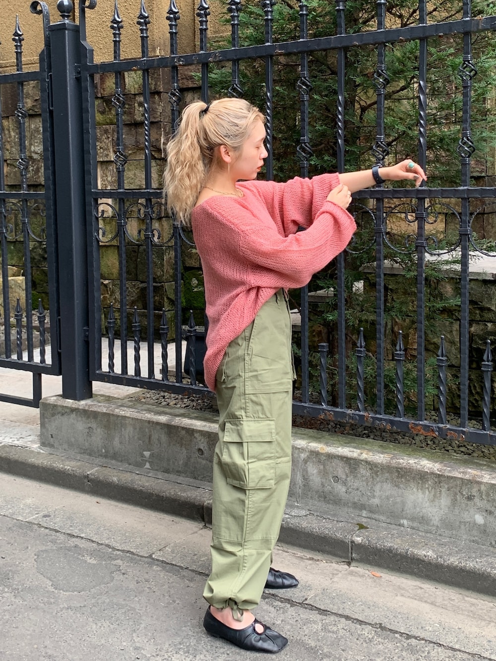 グリーン系のカーゴパンツ、ピンク系のニット/セーターを着用したレディースの秋コーディネートの4枚目の写真