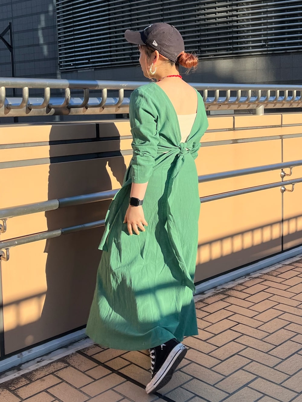 グリーン系のワンピースを着用したレディースの春コーディネートの4枚目の写真