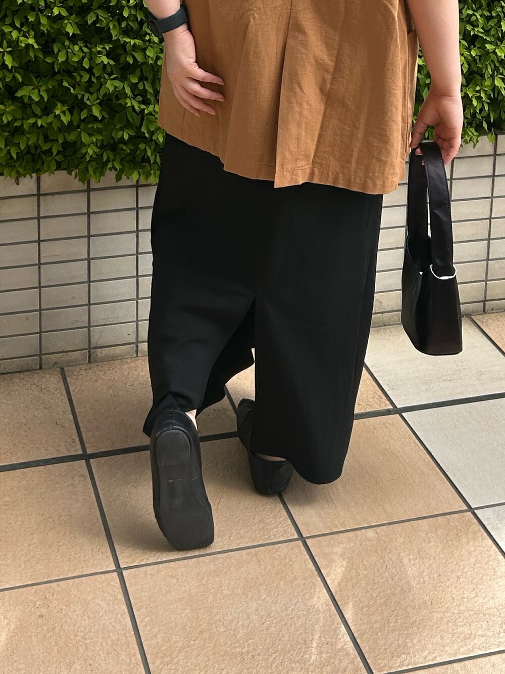 イエロー系のシャツ/ブラウス、ブラック系のハンドバッグ、ブラック系のスカートを着用したレディースの春コーディネートの6枚目の写真