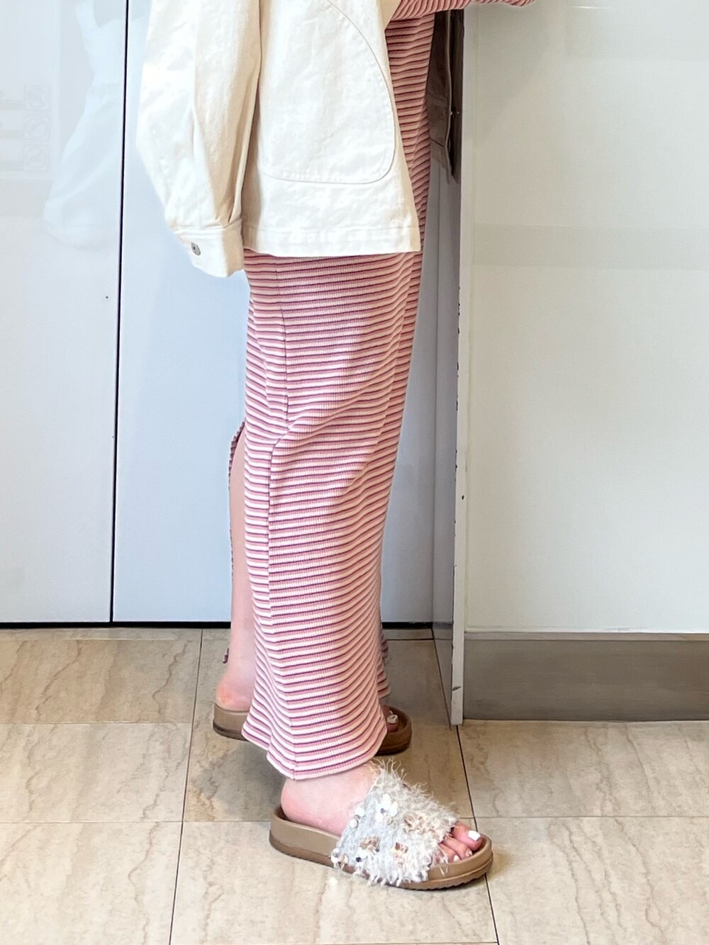 ホワイト系のブルゾン、ピンク系のワンピース、ホワイト系のサンダルを着用したレディースの春コーディネートの6枚目の写真