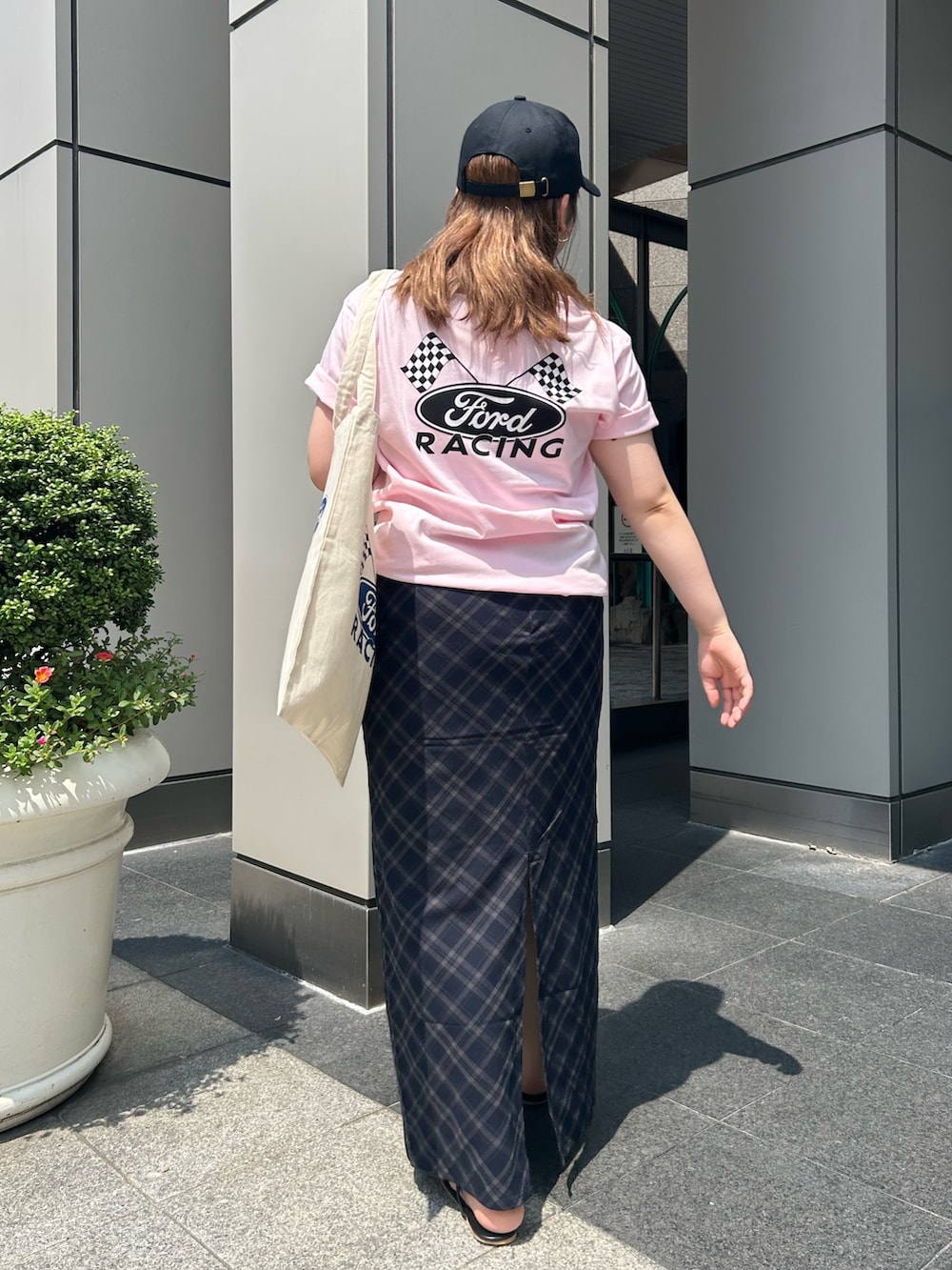 ブルー系のスカート、ピンク系のTシャツ/カットソー、ホワイト系のトートバッグを着用したレディースの夏コーディネートの3枚目の写真