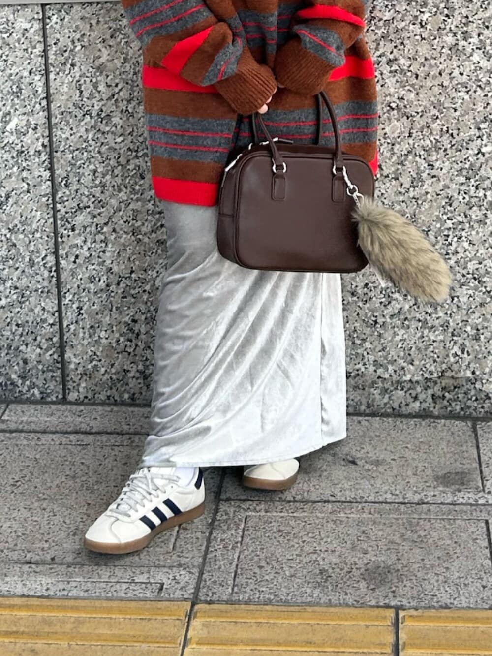 グレー系のスカート、レッド系のニット/セーター、ブラウン系のハンドバッグを着用したレディースの秋コーディネートの5枚目の写真