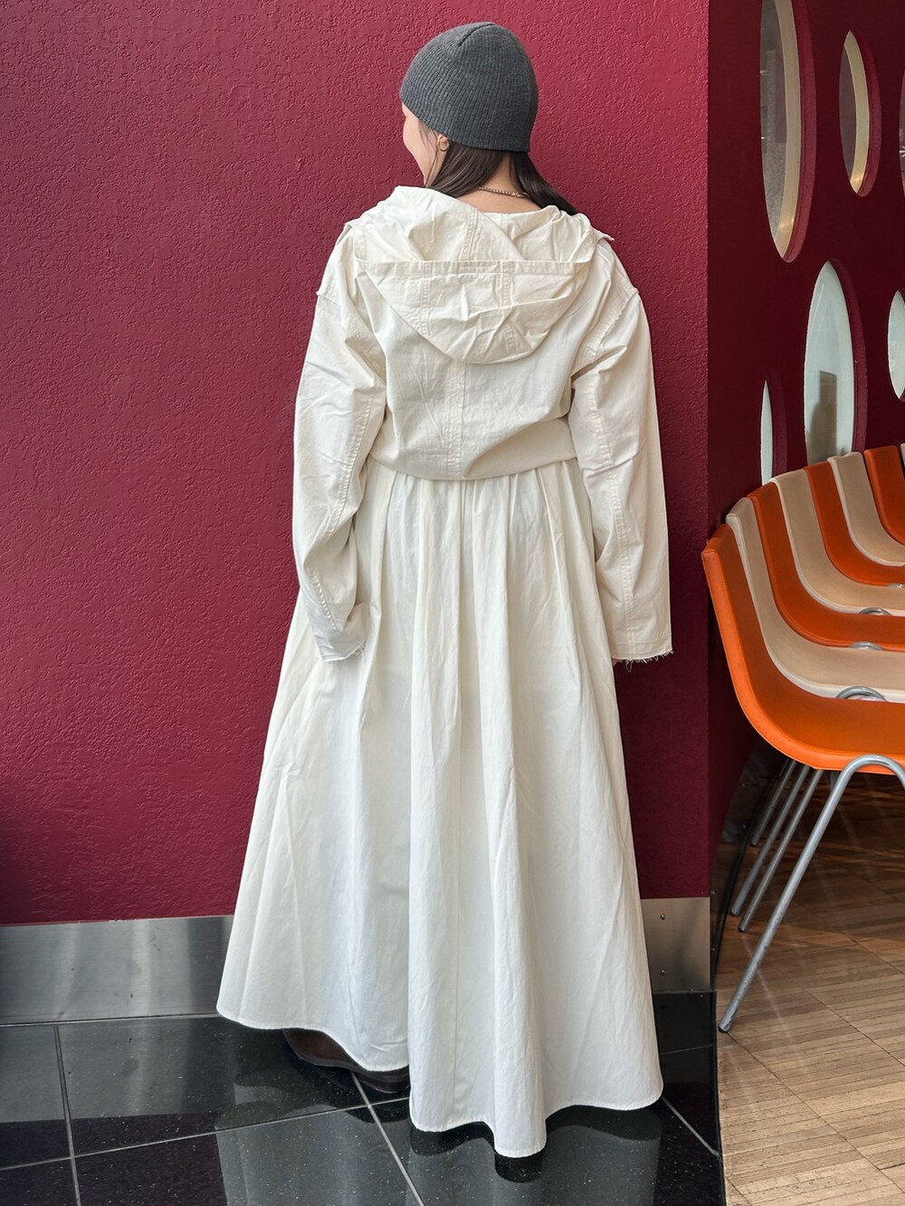 ホワイト系のスカート、ホワイト系のパーカー、ブラウン系のブーツを着用したレディースの秋コーディネートの3枚目の写真