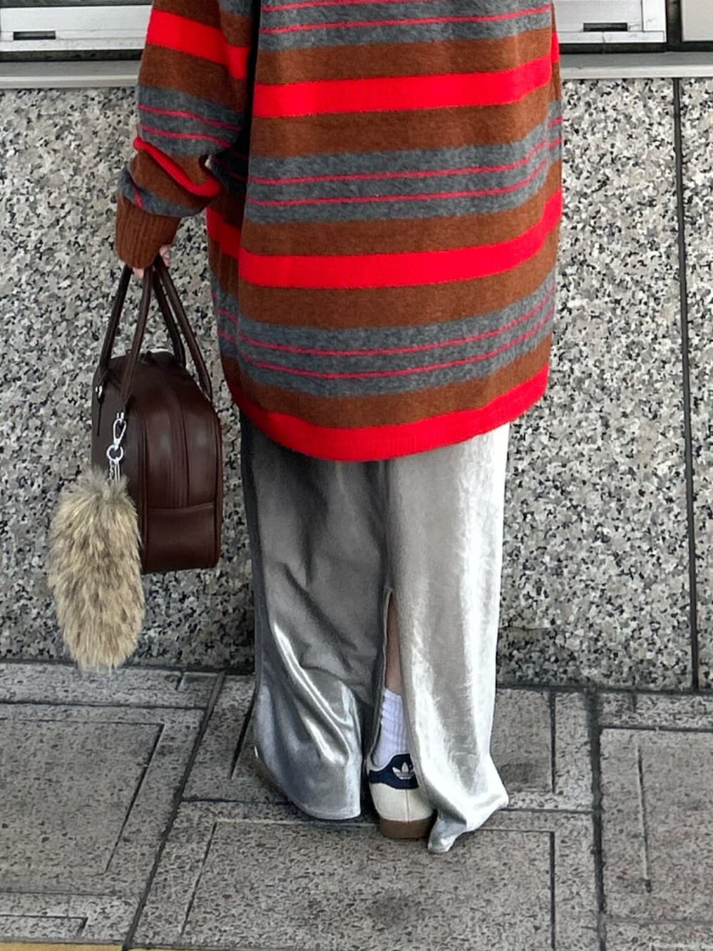 グレー系のスカート、レッド系のニット/セーター、ブラウン系のハンドバッグを着用したレディースの秋コーディネートの7枚目の写真