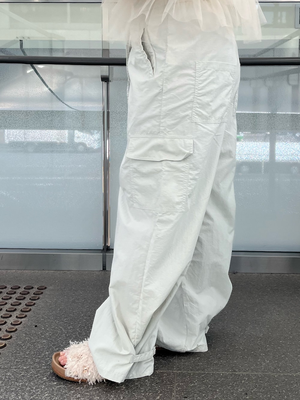 グレー系のサロペット/オーバーオール、ベージュ系のベスト、オレンジ系のTシャツ/カットソーを着用したレディースの冬コーディネートの6枚目の写真