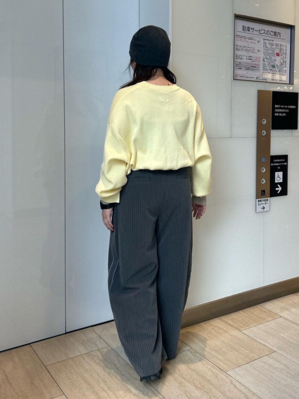 グレー系のその他パンツ、イエロー系のニット/セーターを着用したレディースの冬コーディネートの3枚目の写真