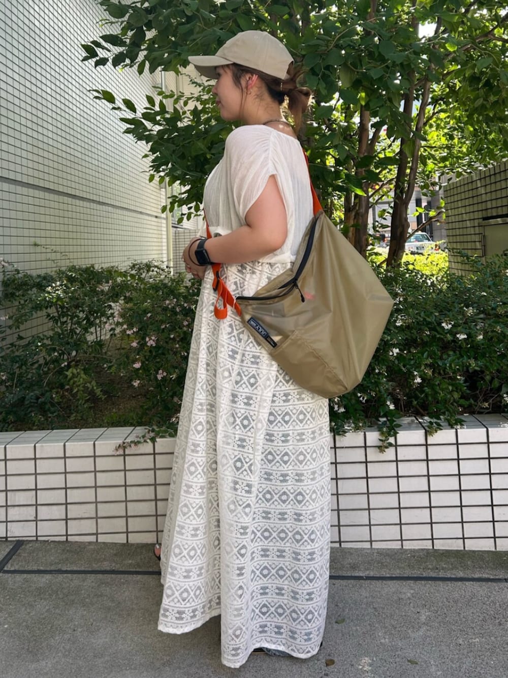 ホワイト系のワンピース、ベージュ系のショルダーバッグを着用したレディースの夏コーディネートの2枚目の写真