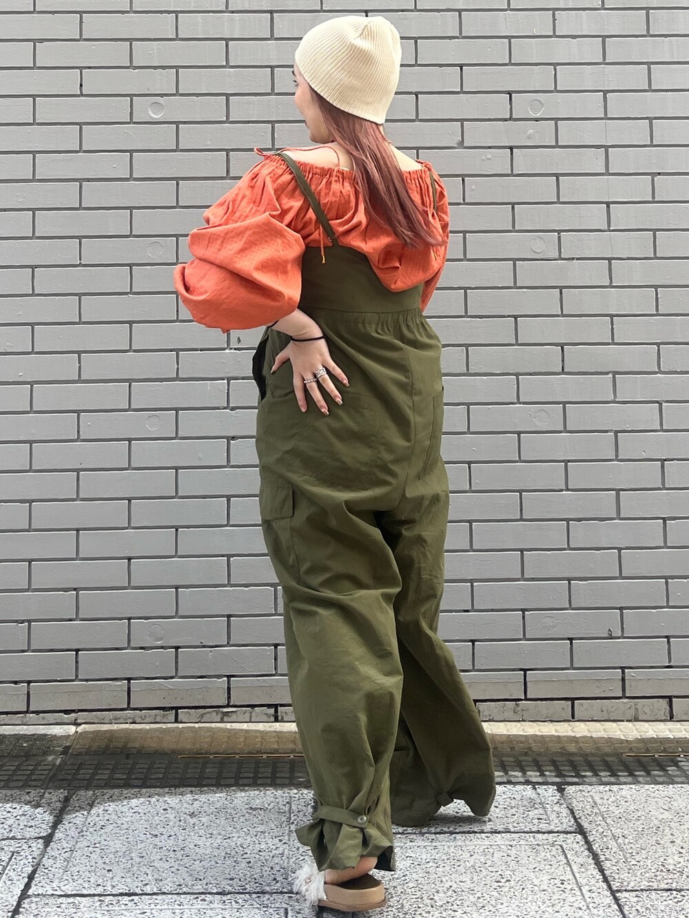 グリーン系のサロペット/オーバーオール、オレンジ系のシャツ/ブラウス、ホワイト系のサンダルを着用したレディースの冬コーディネートの4枚目の写真