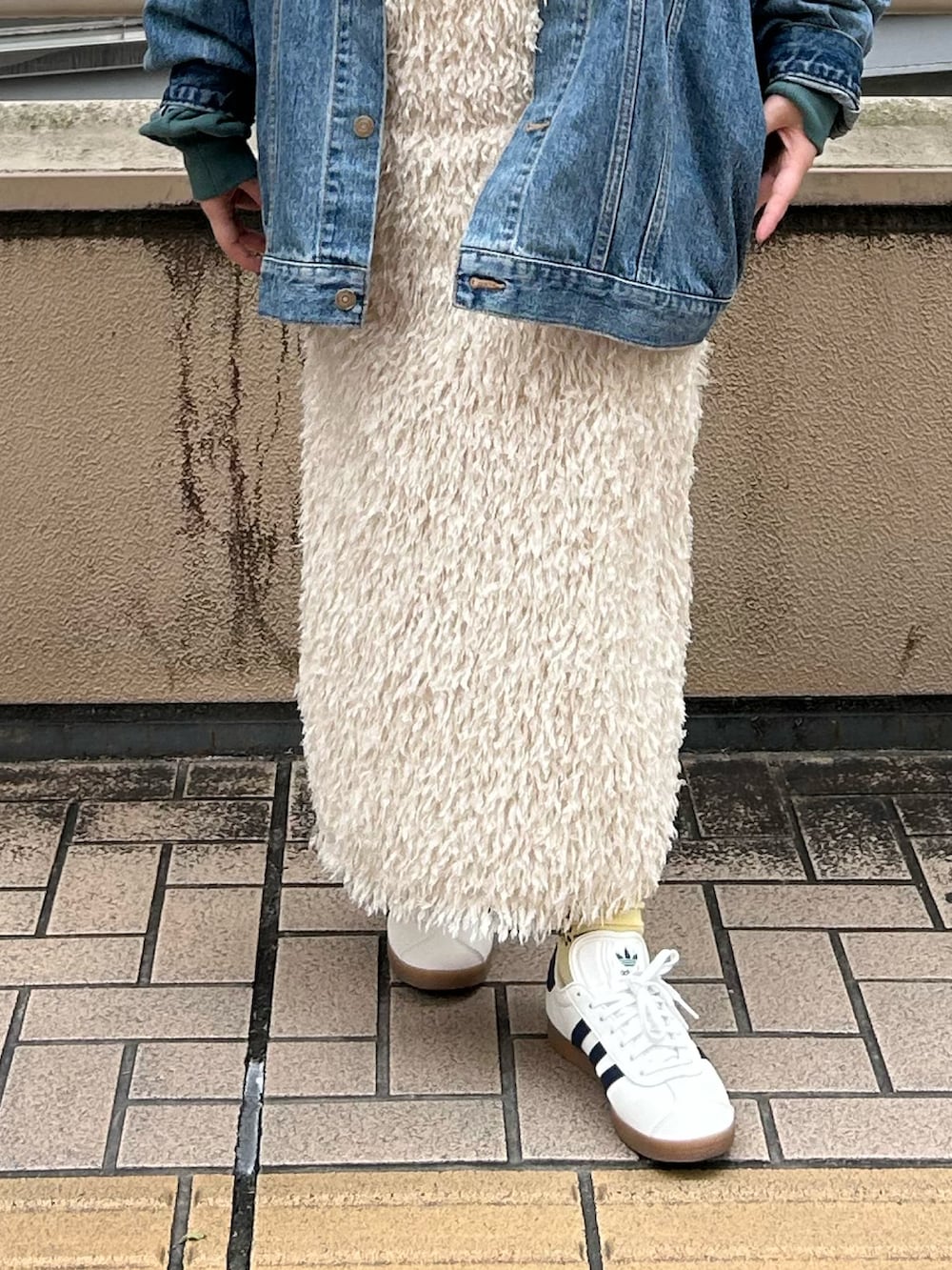 グリーン系のパーカー、ホワイト系のスカート、ブルー系のデニムジャケットを着用したレディースの秋コーディネートの4枚目の写真