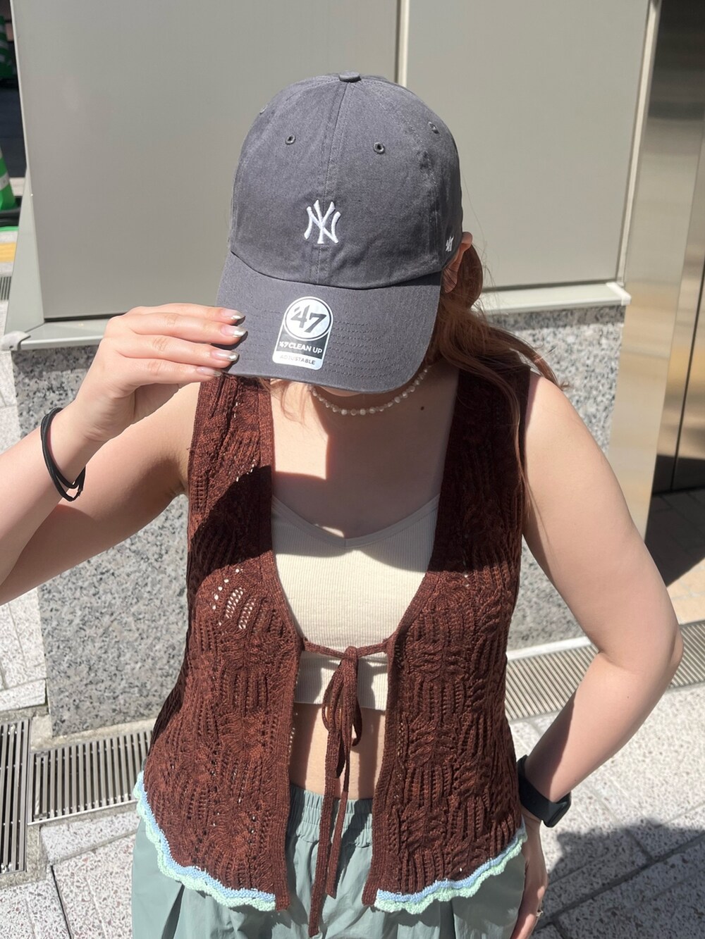 グリーン系のその他パンツ、ブラウン系のニット/セーター、ホワイト系のキャミソールを着用したレディースの春コーディネートの8枚目の写真