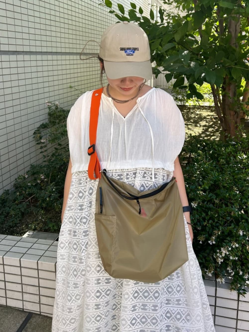 ホワイト系のワンピース、ベージュ系のショルダーバッグを着用したレディースの夏コーディネートの4枚目の写真