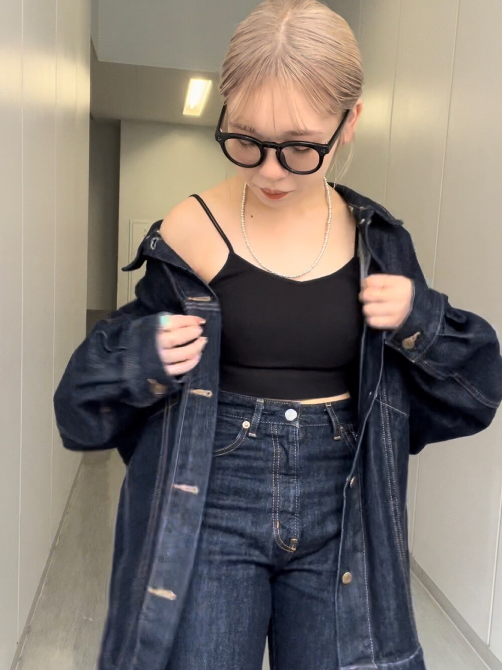 ブルー系のデニムジャケット、ブルー系のデニムパンツ、シルバー系のネックレスを着用したレディースの秋コーディネートの3枚目の写真