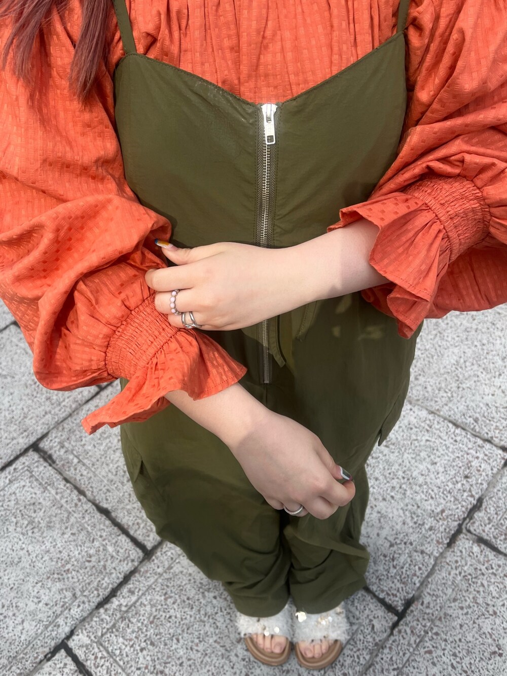 グリーン系のサロペット/オーバーオール、オレンジ系のシャツ/ブラウス、ホワイト系のサンダルを着用したレディースの冬コーディネートの6枚目の写真