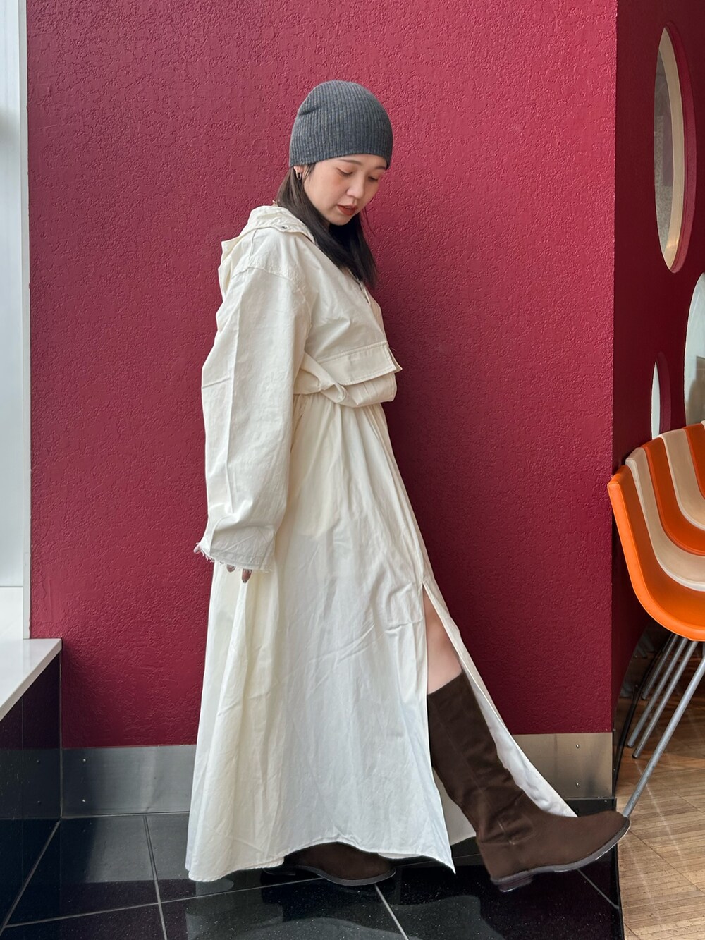 ホワイト系のスカート、ホワイト系のパーカー、ブラウン系のブーツを着用したレディースの秋コーディネートの2枚目の写真