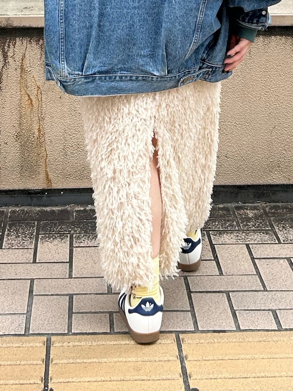 グリーン系のパーカー、ホワイト系のスカート、ブルー系のデニムジャケットを着用したレディースの秋コーディネートの6枚目の写真