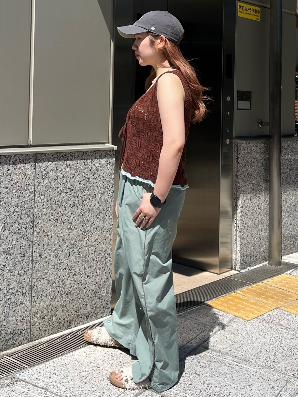 グリーン系のその他パンツ、ブラウン系のニット/セーター、ホワイト系のキャミソールを着用したレディースの春コーディネートの3枚目の写真