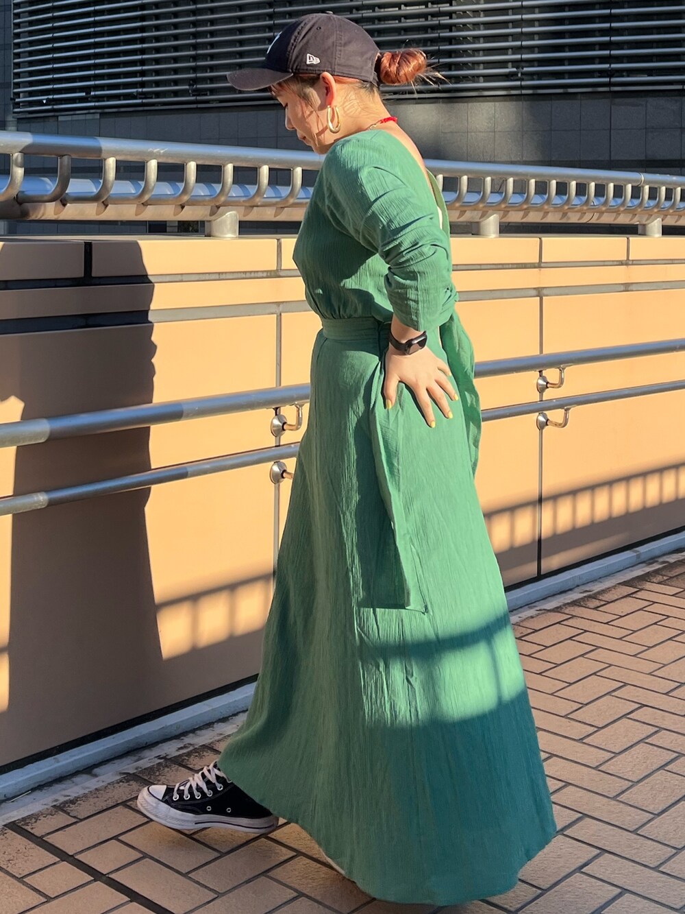 グリーン系のワンピースを着用したレディースの春コーディネートの3枚目の写真