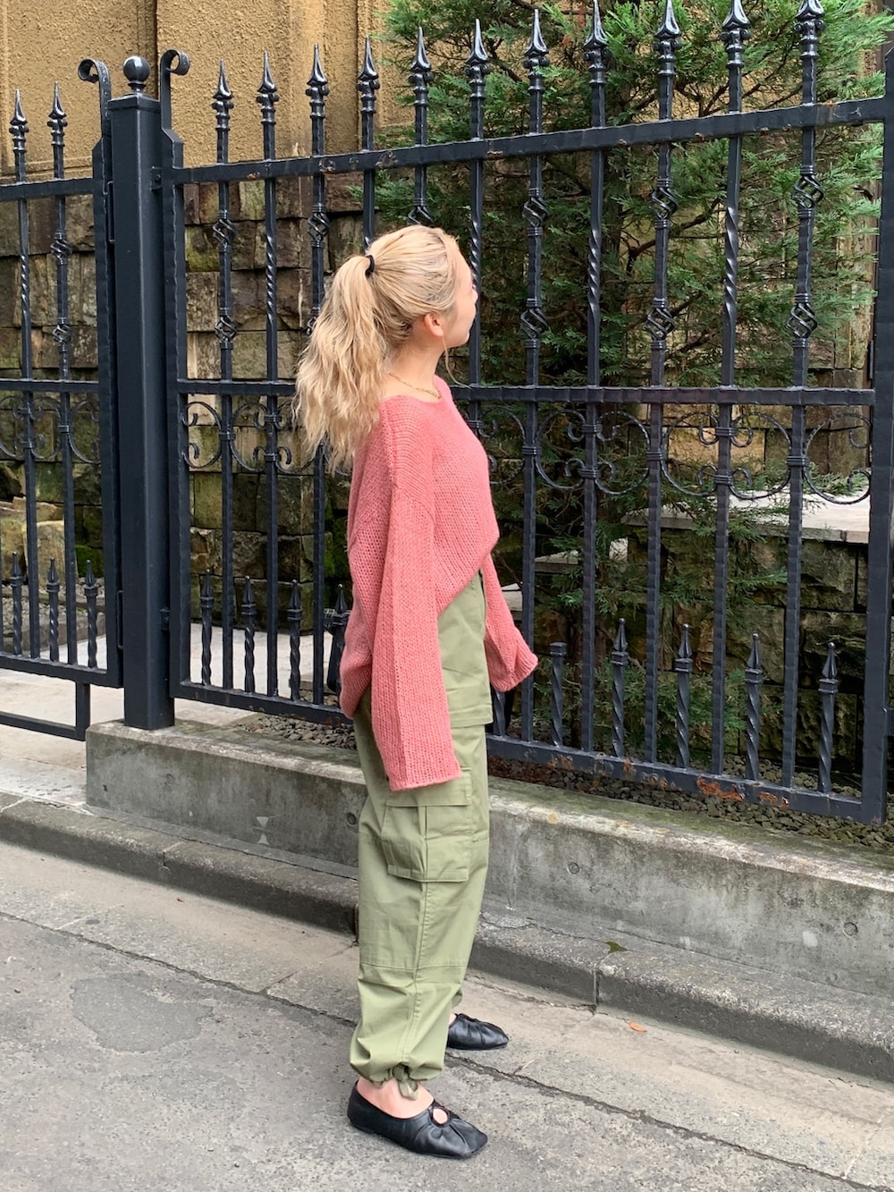 グリーン系のカーゴパンツ、ピンク系のニット/セーターを着用したレディースの秋コーディネートの3枚目の写真