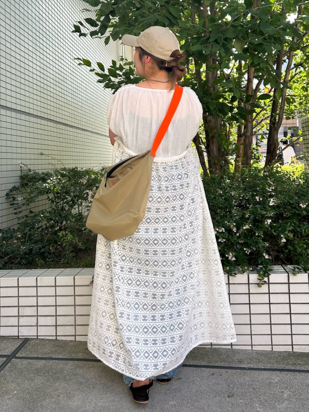 ホワイト系のワンピース、ベージュ系のショルダーバッグを着用したレディースの夏コーディネートの3枚目の写真